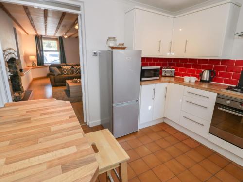 a kitchen with a refrigerator and a table in it at Tryfan in Caernarfon