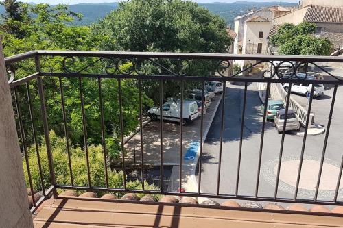 a balcony with a view of a street with cars at Callian: lumineux duplex avec terrasse et vue in Callian