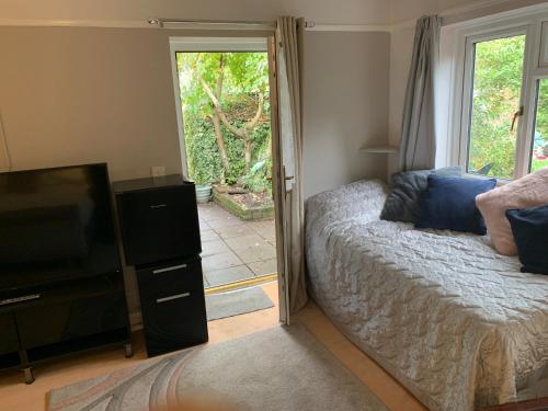 a bedroom with a bed and a flat screen tv at Debbie’s Digs in Ashford