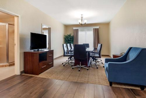 a living room with a table and chairs and a television at Comfort Suites Vicksburg in Vicksburg
