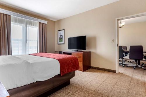 a hotel room with a bed and a flat screen tv at Comfort Suites Vicksburg in Vicksburg