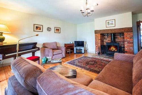 a living room with a couch and a fireplace at Micawbers - Aldeburgh Coastal Cottages in Thorpeness