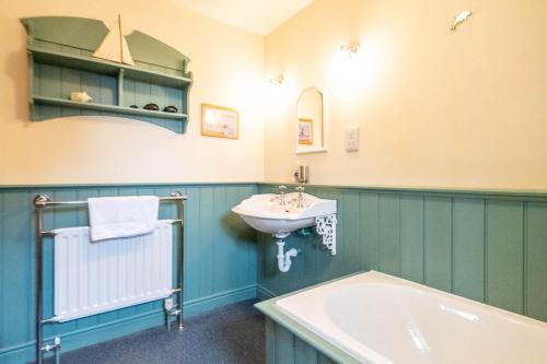 y baño con lavabo y bañera. en Micawbers - Aldeburgh Coastal Cottages, en Thorpeness