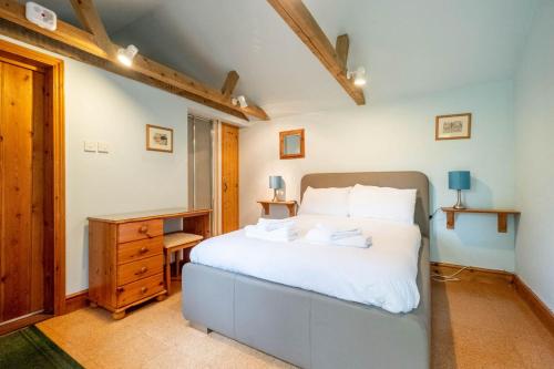 a bedroom with a bed and a desk in it at Micawbers - Aldeburgh Coastal Cottages in Thorpeness