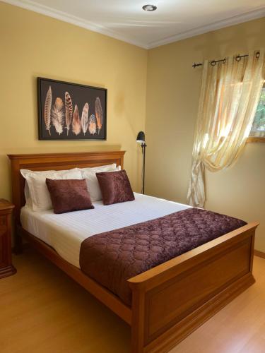 um quarto com uma cama grande e uma janela em Casa da Quinta em Tabuaço