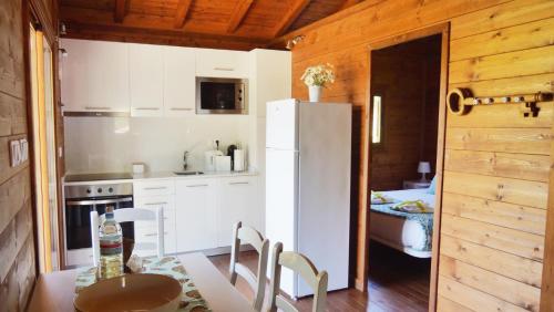 a kitchen with a table and a white refrigerator at Casa Margarida, Quinta Carmo - Alcobaça - Nazaré in Alcobaça