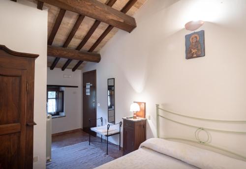 a bedroom with a bed and a table and a chair at Agriturismo Sasso Rosso in Capodacqua