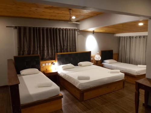 een slaapkamer met 2 bedden in een kamer bij Sunset Beach Hotel in Mirissa