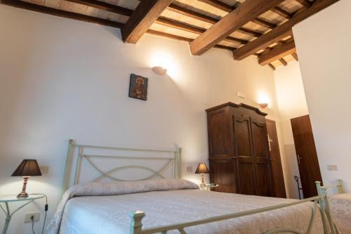 a bedroom with a bed and a wooden cabinet at Agriturismo Sasso Rosso in Capodacqua