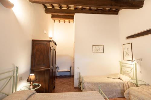 a bedroom with two beds and a dresser at Agriturismo Sasso Rosso in Capodacqua