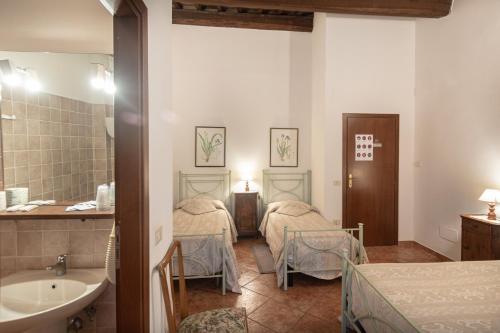 a room with two beds and a sink and a tub at Agriturismo Sasso Rosso in Capodacqua
