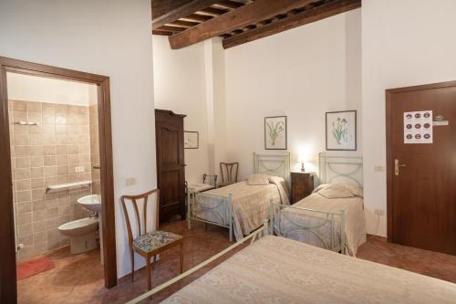 Habitación con 3 camas, lavabo y aseo. en Agriturismo Sasso Rosso en Capodacqua