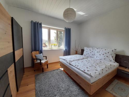 ein Schlafzimmer mit einem Bett, einem Stuhl und einem Fenster in der Unterkunft Ferienhaus Angel in Weitra