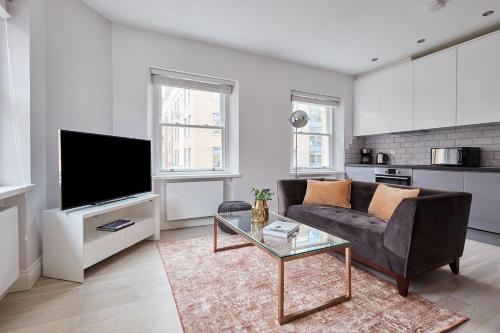 a living room with a couch and a tv at 6VH Virginia House, 31 Bloomsbury Way By City Living London in London