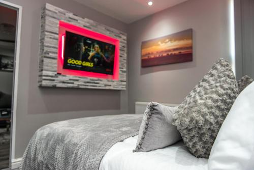 a bedroom with a bed and a tv on the wall at Meridian Serviced Apartments in Bradford