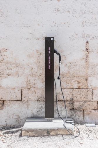a black object sitting next to a brick wall at Masseria Borgo San Marco in Fasano