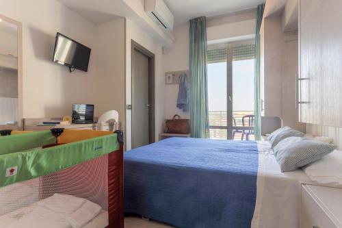 ein Schlafzimmer mit einem Bett und ein Zimmer mit einem Balkon in der Unterkunft Hotel Olympia in Senigallia