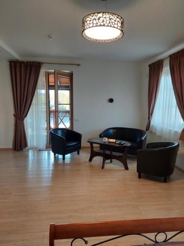 a living room with black furniture and a table at Prie Žiedo in Trakai