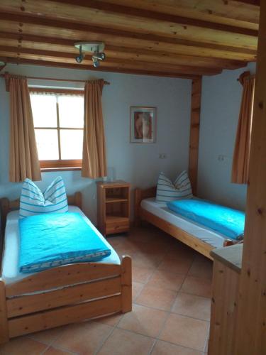 a bedroom with two beds and a window at Fronwieshäusl Gschoßmann Johanna in Ramsau