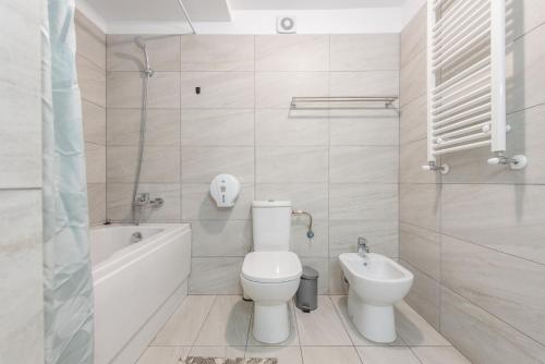 a bathroom with a toilet and a tub and a sink at Royal Accommodation in Bucharest