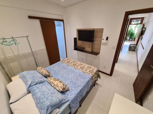 um quarto com uma cama e uma televisão em Vilage novo praia do forte 3 em Mata de São João