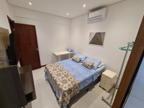 a small bedroom with a bed and a television at Vilage novo praia do forte 3 in Mata de Sao Joao