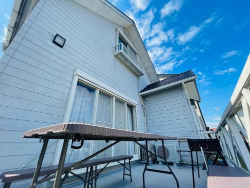 a patio with a table and chairs next to a building at Shanshui House Shin asahi in Takashima