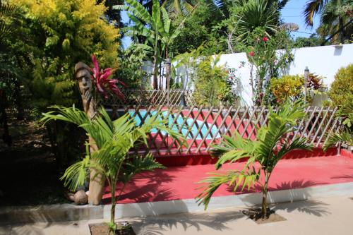 un jardín con una alfombra roja y plantas en VillaKapy idéal pour les retraitées, en Pointe aux Cannoniers