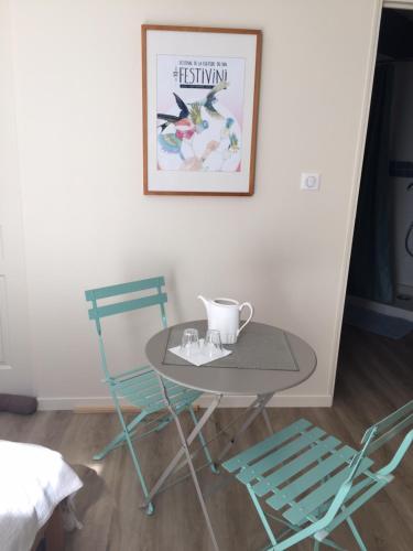 1 mesa y 2 sillas en una habitación en Chambre dans dépendance Maison de Ville + abri vélos en Saumur