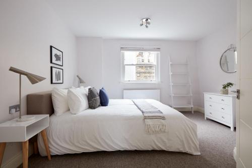 7VH Virginia House, 31 Bloomsbury Way By City Living London في لندن: غرفة نوم بيضاء مع سرير أبيض ونافذة