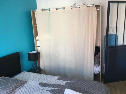 シェルブール・アン・コタンタンにあるSweetie Flatのベッドルーム(ベッド1台、白いカーテン付)