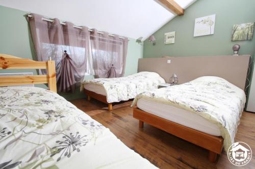 a bedroom with two beds and a window at A l'oree du bois - Gite in Hostun