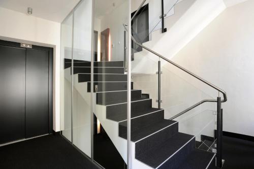 a staircase in a house with a glass wall at The Green Rostock Apartment Hotel in Rostock