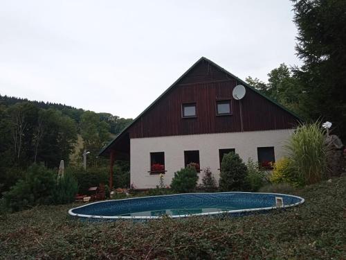 a barn with a swimming pool in front of a house at Chalupa Benecko-M.86 in Benecko