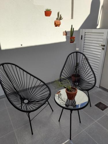 ラファエラにあるDepartamento moderno y luminoso, en planta baja, con patio y excelente ubicaciónの鉢植えの椅子2脚とテーブル