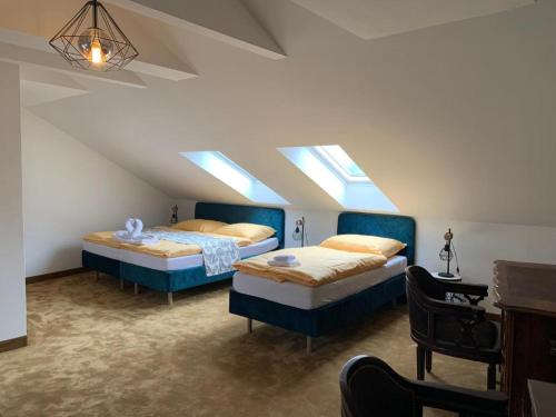 two beds in a room with two windows at Penzión Deloris in Trenčín