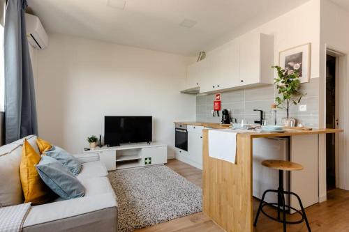 a living room with a couch and a kitchen at Stylish and Elegant Studio - Best View and Location in Coimbra Downton in Coimbra