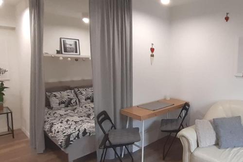 uma sala de estar com uma cama, uma mesa e cadeiras em Lemuria Apartament Szkolna centrum em Legnica