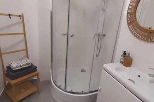 a white bathroom with a shower and a sink at Lemuria Apartament Szkolna centrum in Legnica