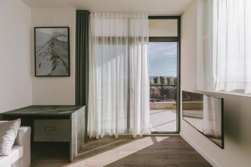 a living room with a large window and a desk at CIM Aparthotel in Sant Cugat del Vallès