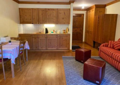 a kitchen and living room with a table and a couch at Studio - La Vièze Thermes Park in Val dʼIlliez