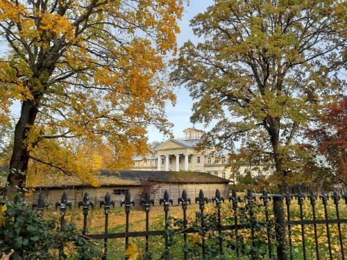 a fence in front of a house with trees at Krimuldas Muiža in Sigulda