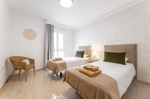 een hotelkamer met 2 bedden en een stoel bij Apartments Urban Arrecife in Arrecife