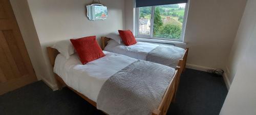 two beds in a room with a window at Hazel's House in Keighley