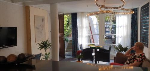 a woman sitting on a couch in a living room at Waar Maas & Waal..... in Woudrichem