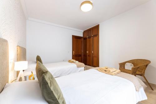 two beds in a room with white walls at Apartments Urban Arrecife in Arrecife