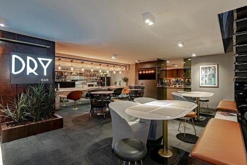 a bar with tables and chairs in a restaurant at Slaviero Curitiba Centro in Curitiba