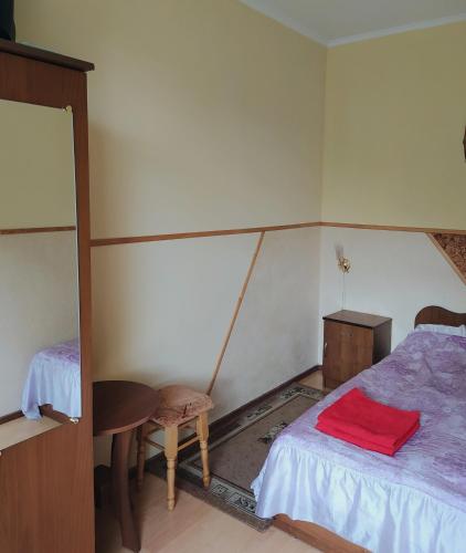 a room with two beds and a table and a table at Sadyba Vyshenka in Tatariv