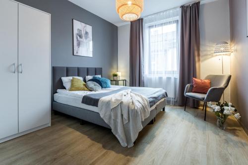 una camera con un grande letto e una sedia di Friendhouse Residence a Cracovia