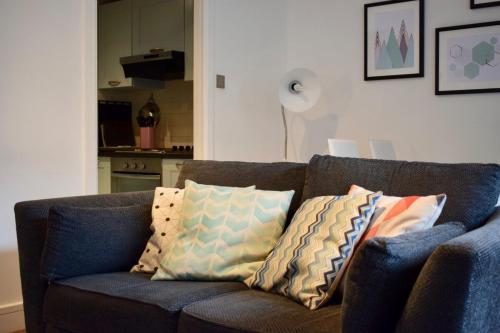 een blauwe bank met kussens in de woonkamer bij Modern and stylish apartment by Grand Canal in Dublin